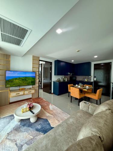 a living room with a couch and a tv at The Kris 2 Bedrooms 2 Bathrooms Apartment in Patong Beach