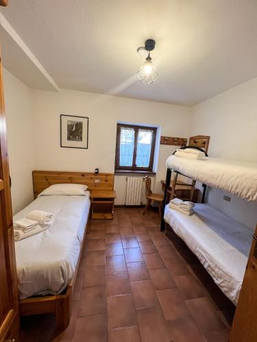 a room with two bunk beds and a window at Casa Vacanze Ca' De Val in Campodolcino