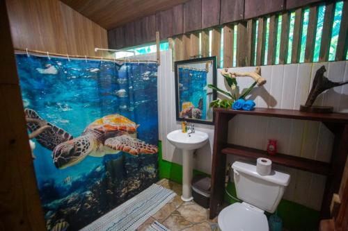 Los Paniquines Ecolodge في دريك: حمام ذو طابع بحري مع ستارة دش على شكل سلحفاة