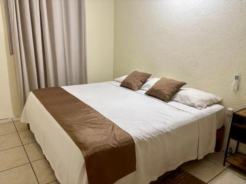 a bed with two pillows on it in a room at Casa Leon Rinconada in Puerto Escondido
