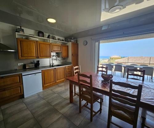 a kitchen with a table and a dining room with a view at Paradiso Apartment 4 people in Furiani