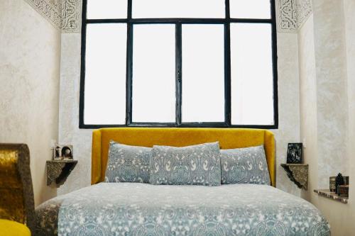 Un dormitorio con una cama con una ventana grande. en Riad Amelia Badr Soultan Room, en Tetuán