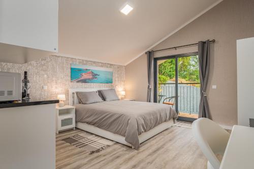 Un dormitorio con una cama y una ventana grande. en Madeira Sunrise Villa, en Gaula