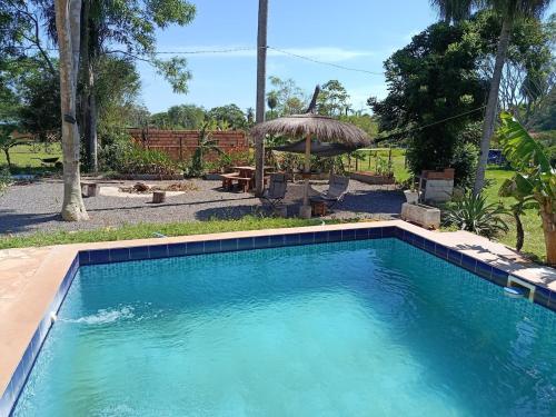 una piscina con sombrilla en un patio en Che Jazmin, your haven of peace and harmony, en Itá