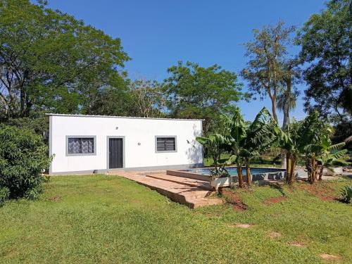 una casa blanca con piscina en un patio en Che Jazmin, your haven of peace and harmony, en Itá