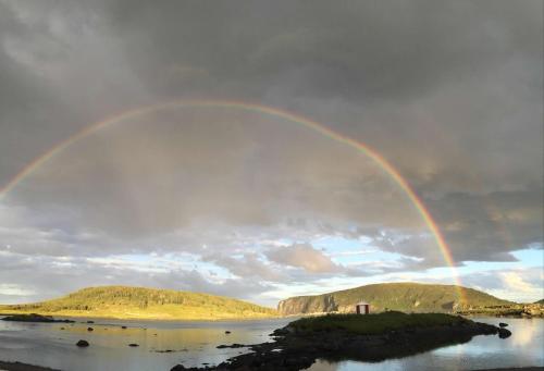 a rainbow in the sky over a body of water at Wildnorth Hotel in St. Anthony