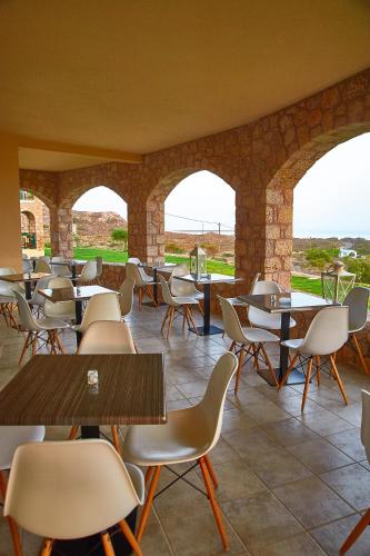 a restaurant with tables and chairs and windows at Element Hotel in Elafonisos