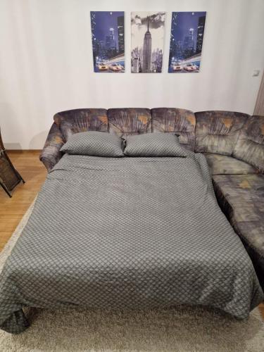 a large bed in a room with a couch at Aleksandrija Pale in Pale
