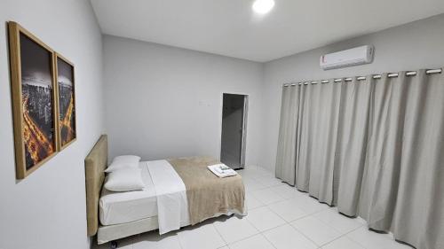 een witte slaapkamer met een bed en een raam bij Hotel Almany in Palmas