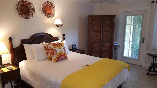 a bedroom with a large bed with a yellow blanket at The Caribbean Court Boutique Hotel in Vero Beach