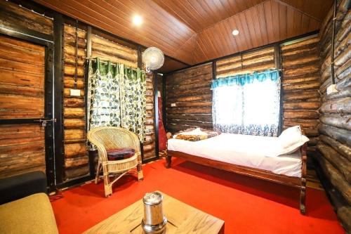 een slaapkamer met een bed in een blokhut bij Cliff Inn Mountain Resort in Vagamon