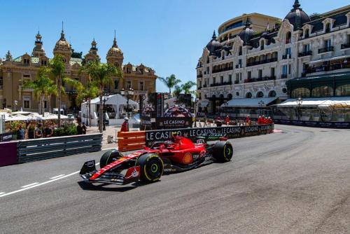 um carro de corrida vermelho dirigindo em uma pista de corrida em Le COQ Charlene - Monaco at 50m em Monte Carlo