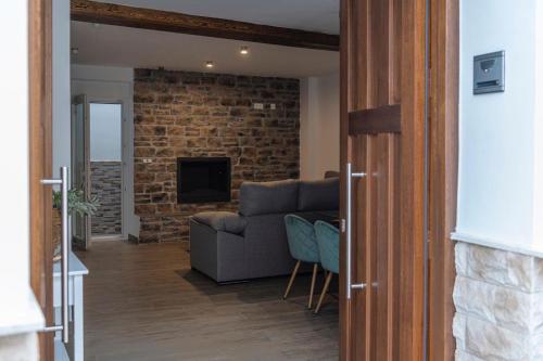 a living room with a couch and a brick wall at Pico Mágina in Albanchez de Magina