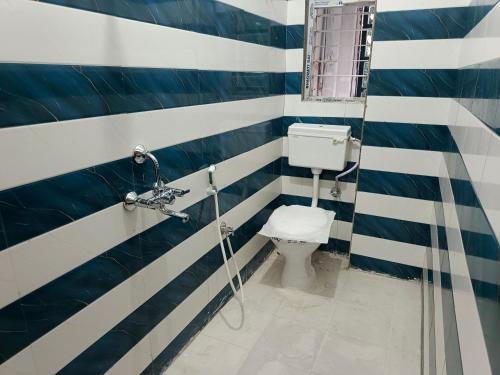 a bathroom with a toilet with blue and white stripes at Purabi homestay in Silchar
