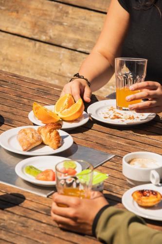 una mujer sentada en una mesa con platos de comida en WOT Ericeira Surf Social, en Ericeira