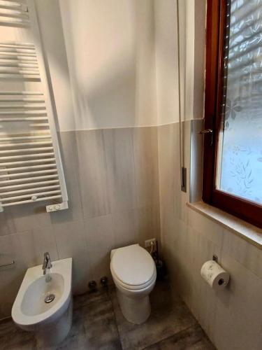 a bathroom with a toilet and a sink and a window at Le Stanze di Bimba in Terni
