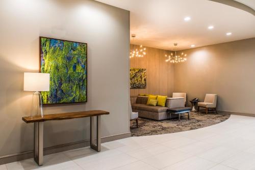 a waiting room with a couch and a painting on the wall at Comfort Inn & Suites Valdosta I-75 in Valdosta