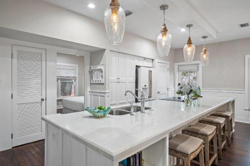 The Magnolia Mermaid في بنما سيتي بيتش: مطبخ مع جزيرة بيضاء كبيرة مع كراسي بار