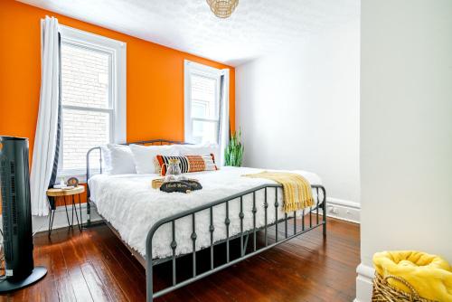 um quarto com uma parede laranja e uma cama em Jungle House Luxury Stays - Columbus Downtown Short North em Columbus