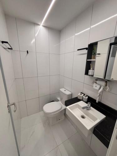 un bagno bianco con un water e un lavandino di Quarto master Fortaleza Sul a Fortaleza
