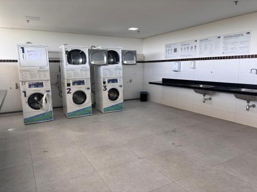 quattro lavatrici e asciugatrici in una lavanderia di Quarto master Fortaleza Sul a Fortaleza