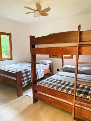 una camera con 2 letti a castello e un ventilatore a soffitto di Villa refugio de paz a Bayaguana