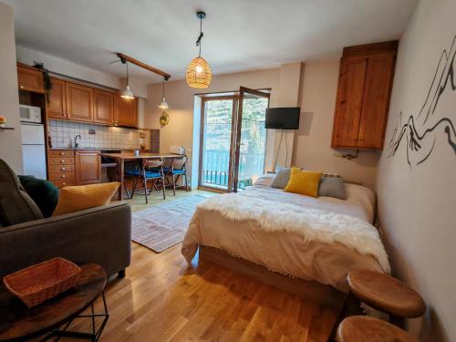 a bedroom with a bed and a kitchen with a table at Tu rincón rústico con balcón y vistas - Erta 2 in Pla de l'Ermita