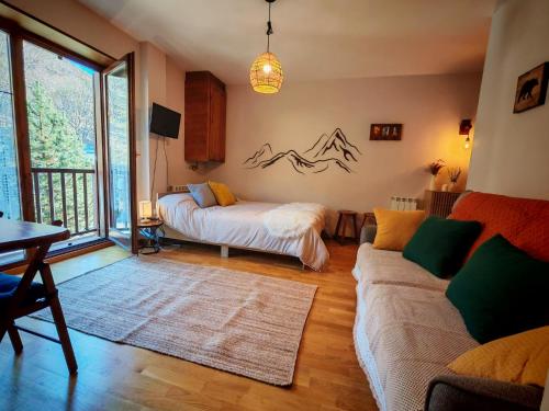 a living room with a bed and a couch at Tu rincón rústico con balcón y vistas - Erta 2 in Pla de l'Ermita