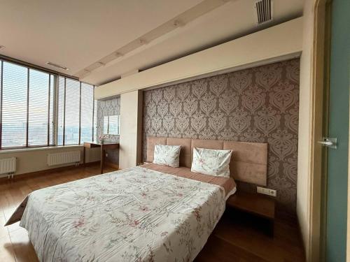 een slaapkamer met een groot bed en een groot raam bij Мост сити АПП 138 ЛЮКС in Dnipro