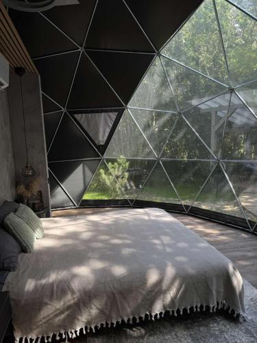 ein Schlafzimmer mit einer großen Glaswand in der Unterkunft Tyla dviese in Kaciūniškiai