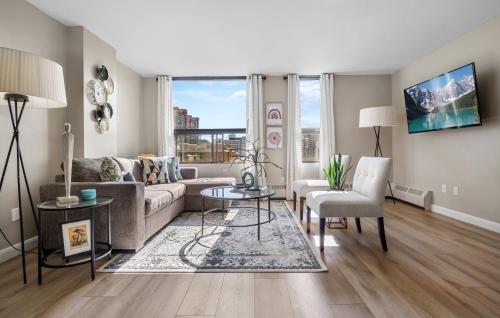a living room with a couch and a table at Reduced for Spring! Stylish Condo & Easy to Mountains ! in Calgary