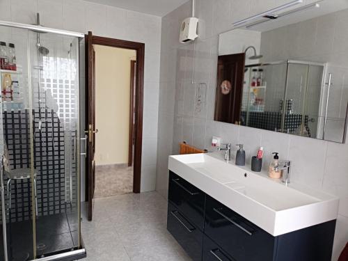 a bathroom with a white sink and a shower at Casa Castro in A Estrada