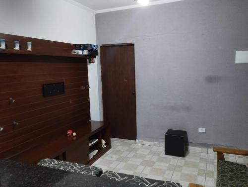 Cette chambre est dotée d'un mur avec une porte et une table. dans l'établissement Residence Lisboa, à Itanhaém