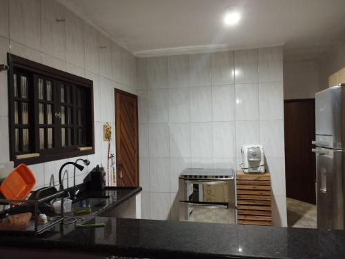 une cuisine avec un évier et un réfrigérateur dans l'établissement Residence Lisboa, à Itanhaém