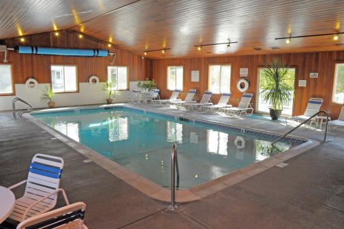 a large swimming pool in a building with chairs at Elmwood Resort Hotel in Wells