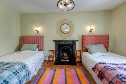 3 Bed in Llansteffan oc-78278 في Llanstephan: سريرين في غرفة بها موقد