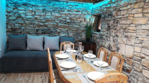 een houten tafel met stoelen en een bank in een kamer bij Juniper Stone Cottage by Villas Guide in Alavanja