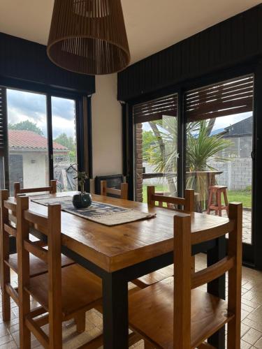 Travesia Sur Hostel في إل بولسون: غرفة طعام مع طاولة وكراسي خشبية