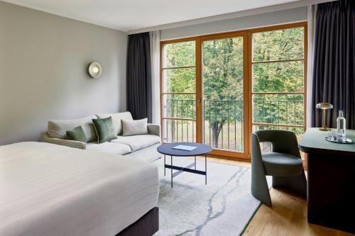 a hotel room with a bed and a couch at Bollants SPA im Park, Autograph Collection in Bad Sobernheim