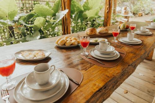 un tavolo in legno con piatti di cibo e bicchieri di vino di Villa Milos a Fernando de Noronha
