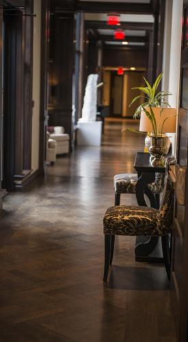 a hallway with a chair and a table with a plant at The Bruce Hotel in Stratford