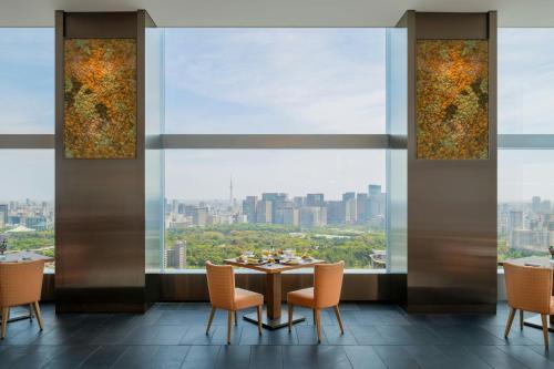 a dining room with a table and chairs and a large window at The Prince Gallery Tokyo Kioicho, a Luxury Collection Hotel in Tokyo