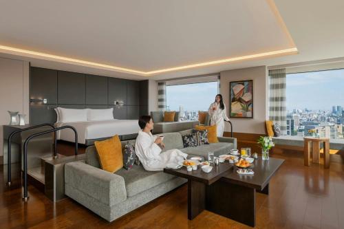 a man sitting on a couch in a hotel room at The Prince Gallery Tokyo Kioicho, a Luxury Collection Hotel in Tokyo