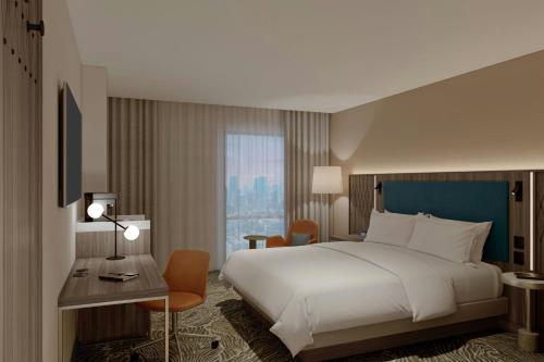 a hotel room with a large bed and a desk at Courtyard by Marriott Guadalajara Andares in Zapopan