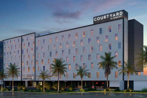 a rendering of a hotel with palm trees in front at Courtyard by Marriott Guadalajara Andares in Zapopan