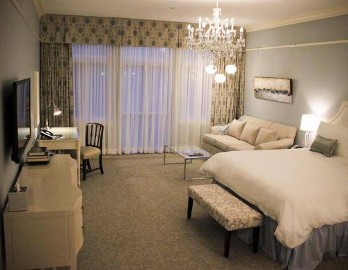 a bedroom with a large bed and a living room at The Bruce Hotel in Stratford
