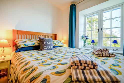 a bedroom with a large bed and a window at 3 Bed in Polperro oc-h34100 in Polperro