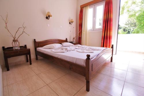 a bedroom with a bed and a large window at Ampavris Family Apartments in Kos Town
