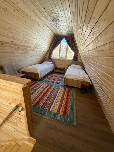 Alban في Saty: غرفة صغيرة بها سريرين ونافذة