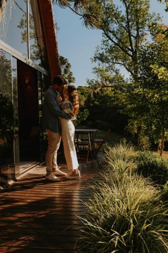 a man and a woman standing outside of a building at Cabana Amélia, em Gramado in Gramado